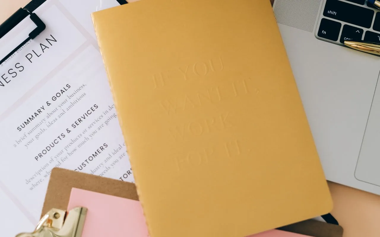 A business plan and planner open on a desk for the annual rate review, before the first quote of the year goes out.