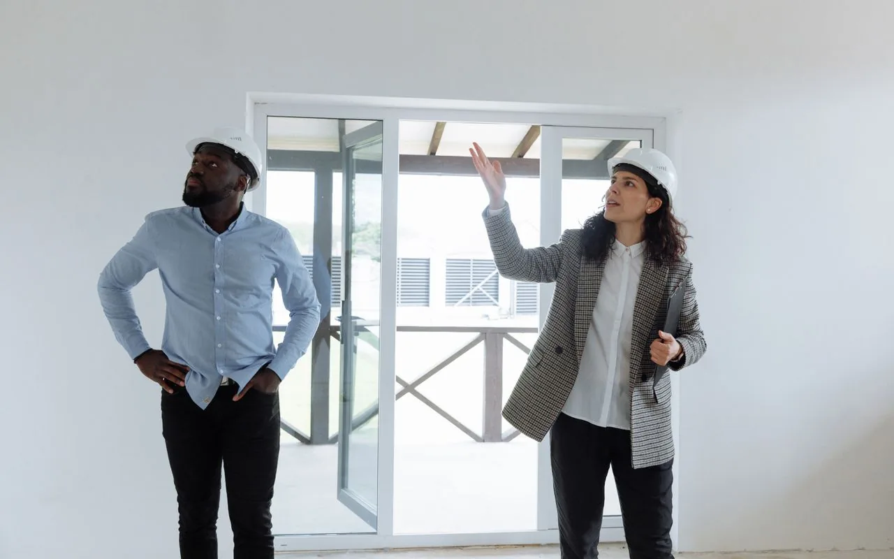 A client gesturing at something in a room while the contractor listens — the moment a variation is born.