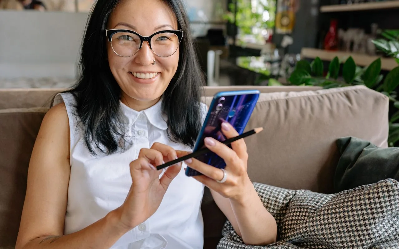 A homeowner on her phone at home, a week after the job — the moment the review request should land.