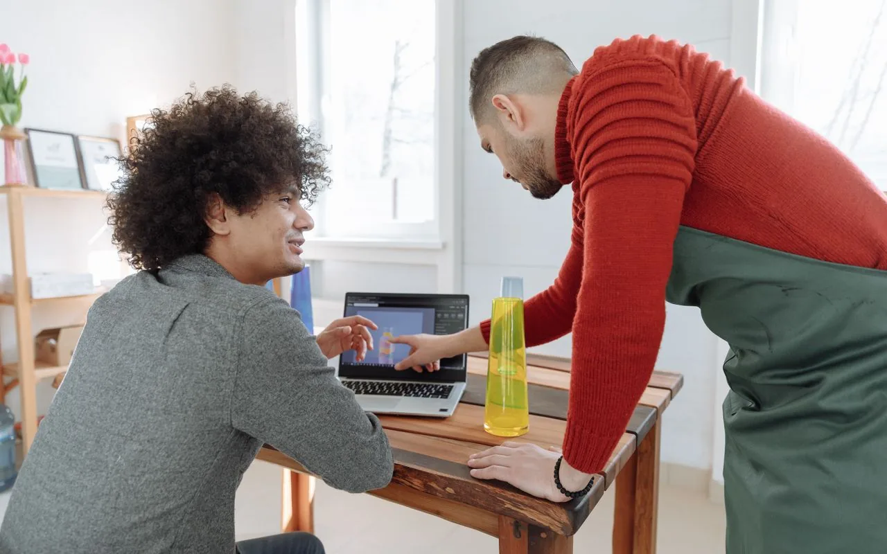 Two people working through pricing on a laptop, so the rate card lives in the business rather than in one estimator.
